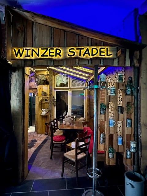 Beleuchteter Schriftzug „Winzer Stadel“ über dem Eingang zum Nebenraum